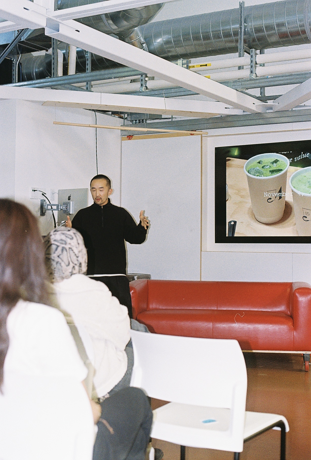 Film photo of the speaker presenting at the d.school event